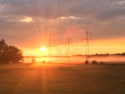 sun behind power lines